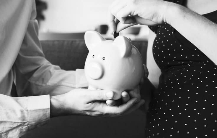 Man and woman saving money in piggy bank #nospendchallenge