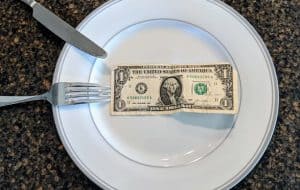 fork, knife, dinner plate and dollar bill